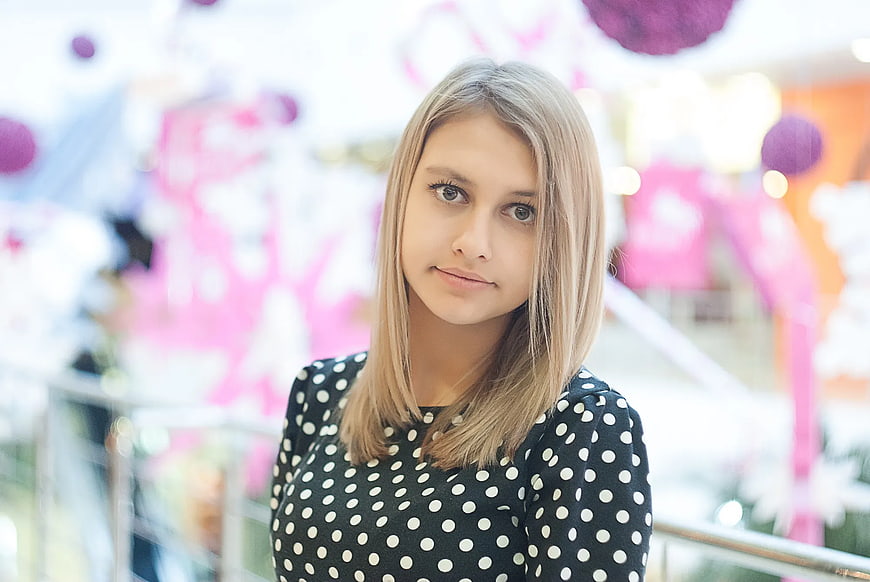 Portrait of young woman in polka dot dress at shopping mall