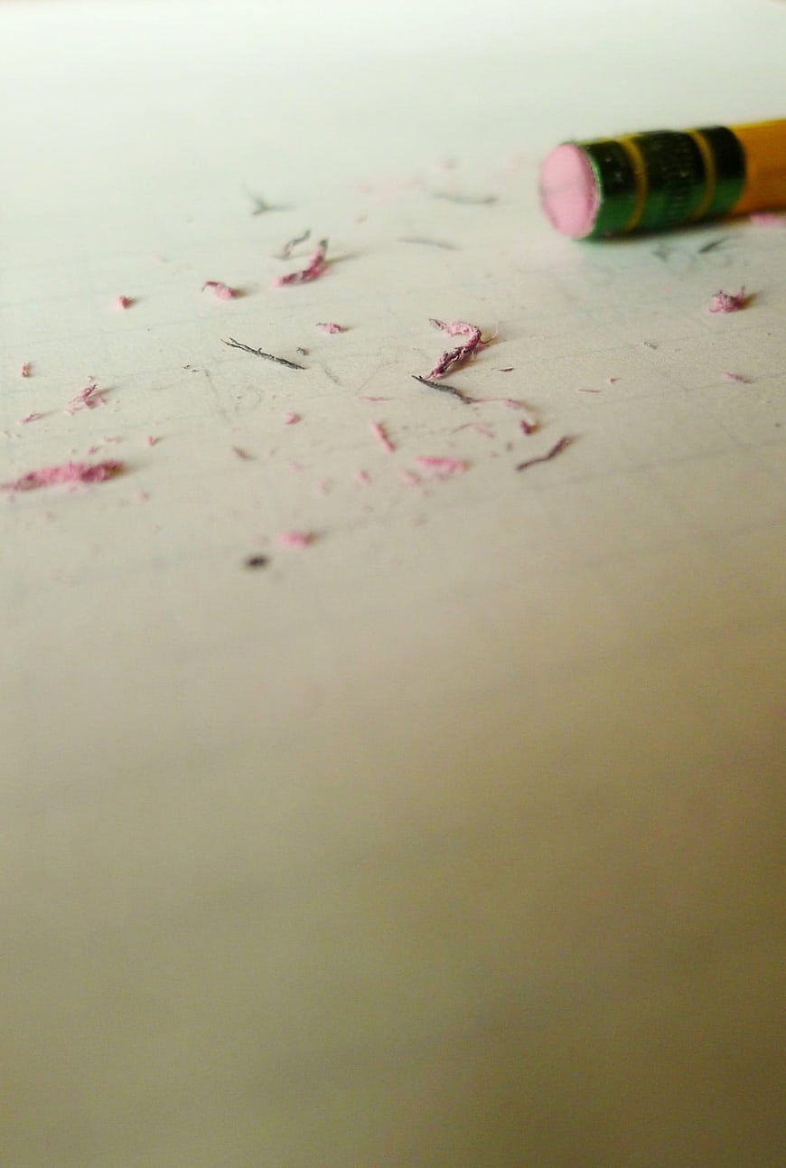 Pink pencil eraser and shavings on white paper background