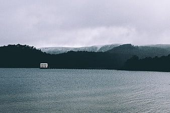 Misty Lake Landscape with White Pavilion and Forested Hills