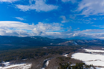 Aerial View of Snowy Winter Mountains and Forest Landscape