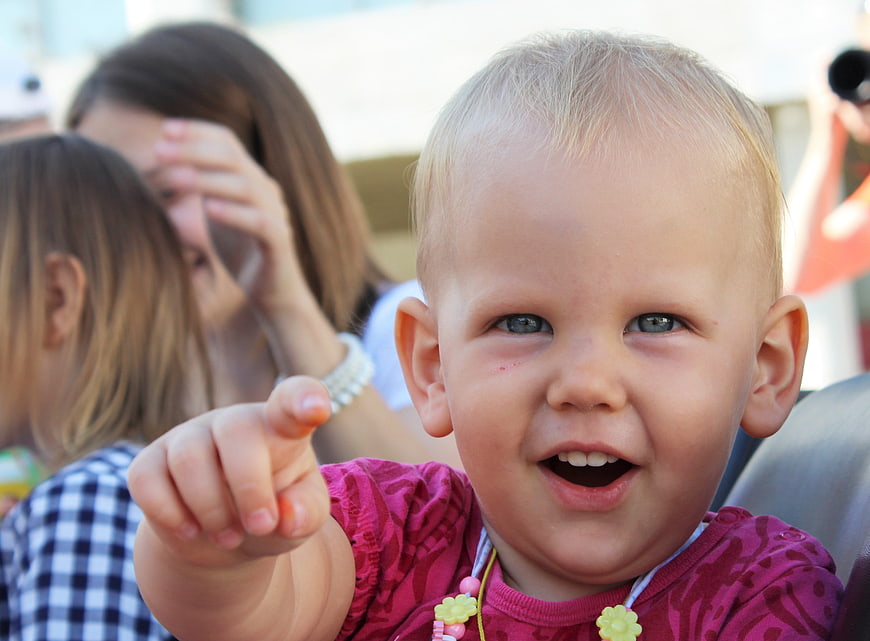 Cute Baby Girl Pointing Finger and Smiling