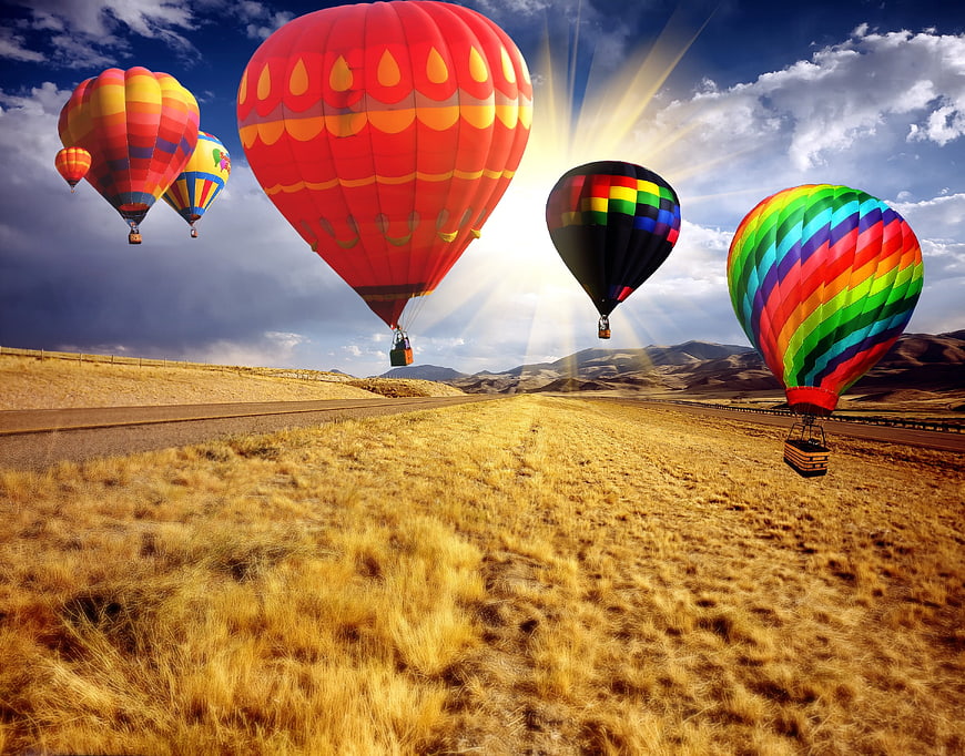 Colorful Hot Air Balloons Flying Over Golden Countryside