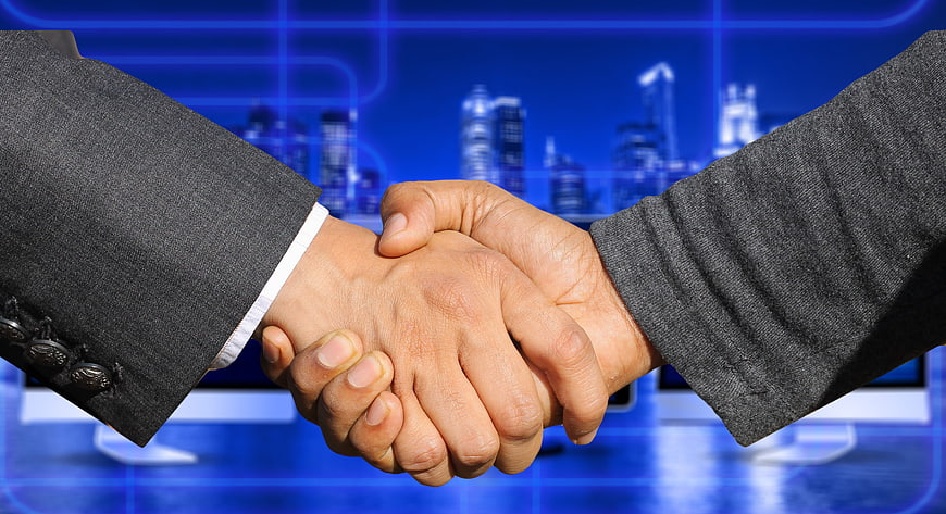Business Handshake Against Blue Digital City Skyline Background