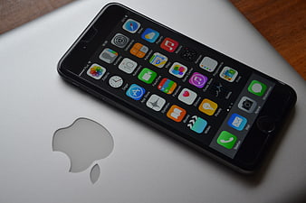 Black iPhone 6 Plus on Silver MacBook Pro with Apple Logo