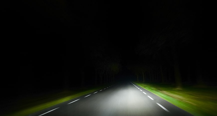 Dark Road at Night with Headlights and Trees