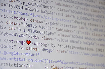 Close-up of HTML code with red heart icon on screen
