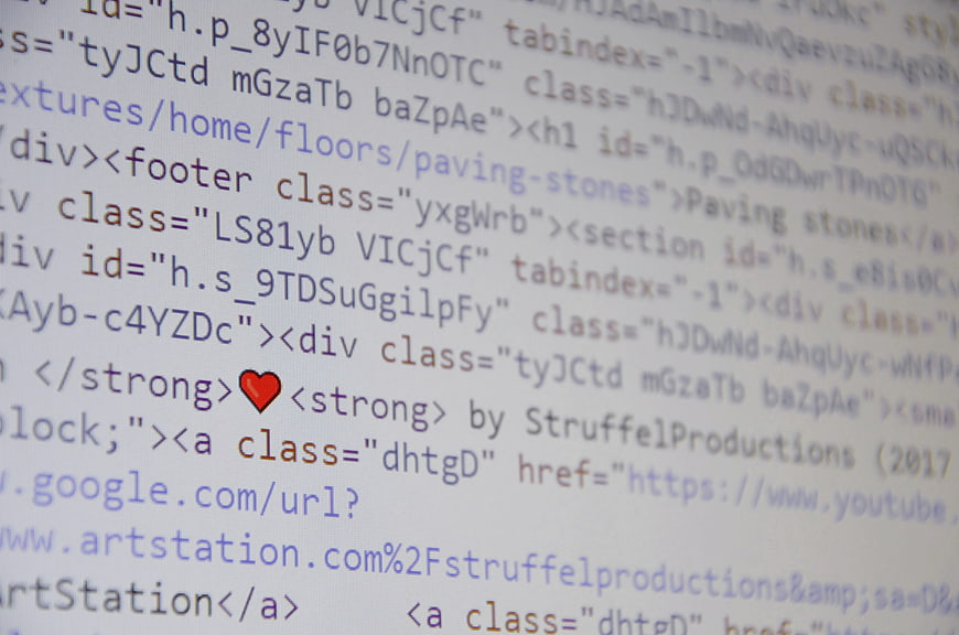 Close-up of HTML code with red heart icon on screen