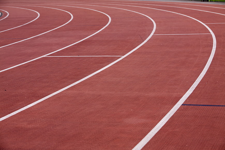 Red running track with white lane lines