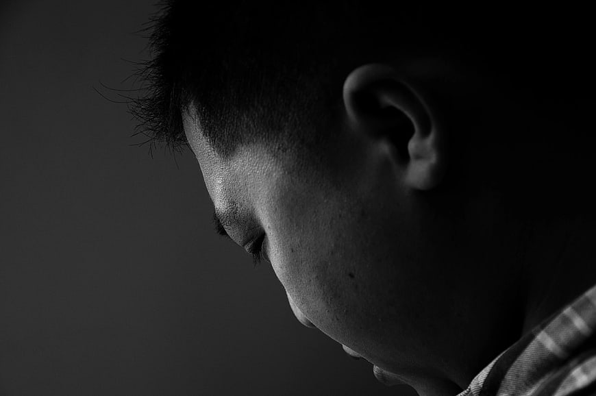 Close-up profile of man looking down in black and white