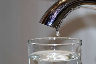 Water Dropping from Chrome Faucet into Glass