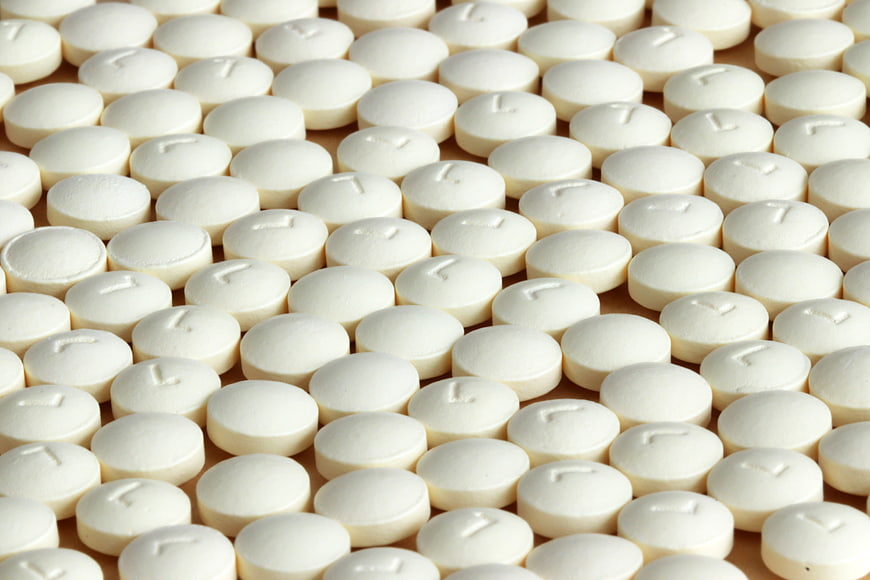 Close-up of white round pharmaceutical tablets with imprinted markings