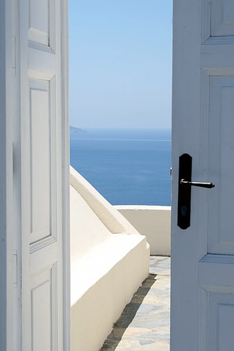 Open White Door Framing Blue Sea View