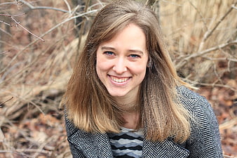 Smiling young woman portrait in herringbone coat outdoors