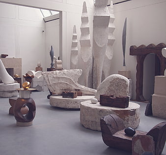 Modern art gallery interior with abstract stone and wood sculptures