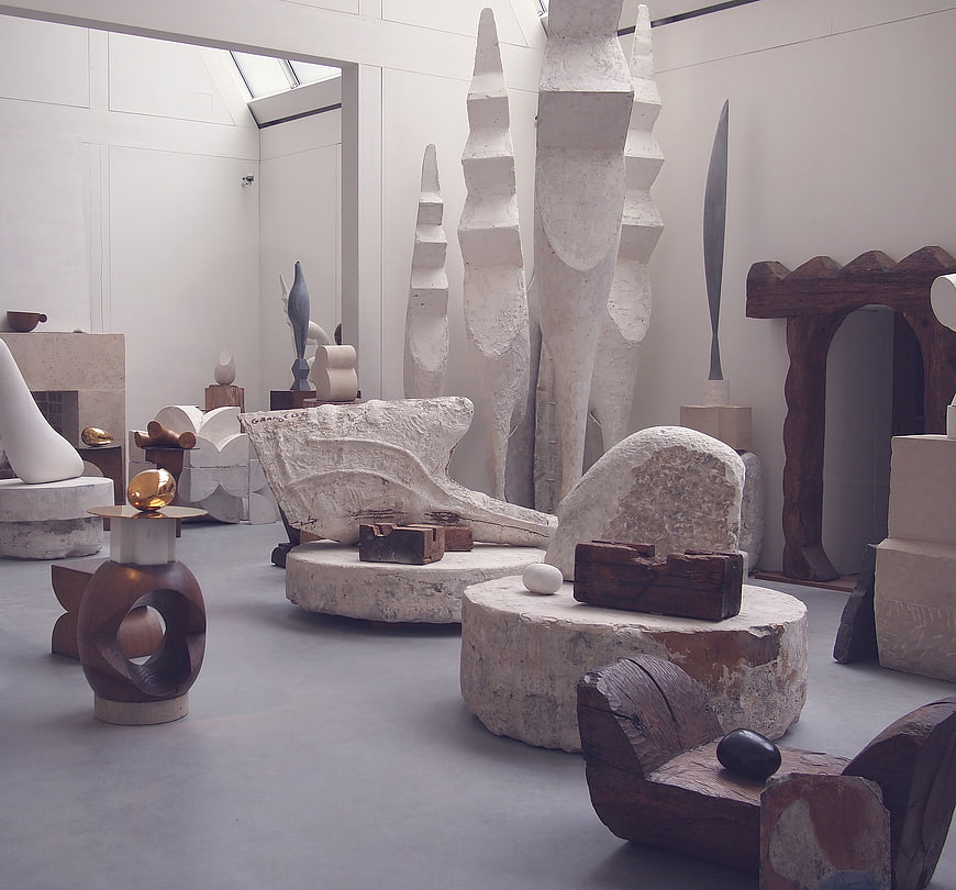 Modern art gallery interior with abstract stone and wood sculptures