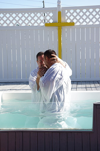 Christian Baptism Ceremony in Outdoor Pool with Yellow Cross