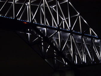 Illuminated steel bridge truss structure at night