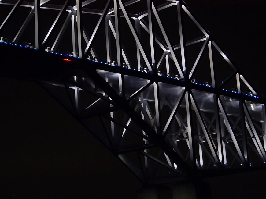 Illuminated steel bridge truss structure at night