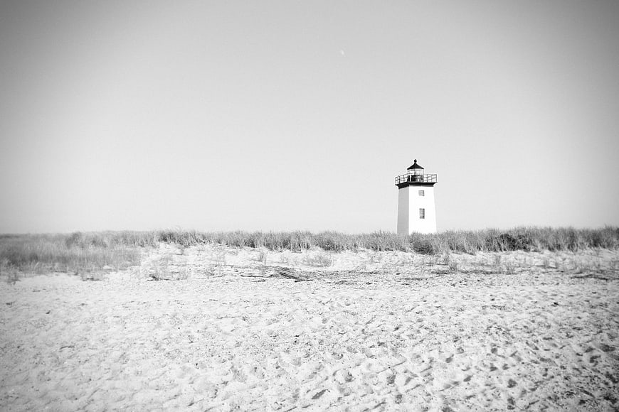 Minimalist Black and White Lighthouse on Sandy Beach