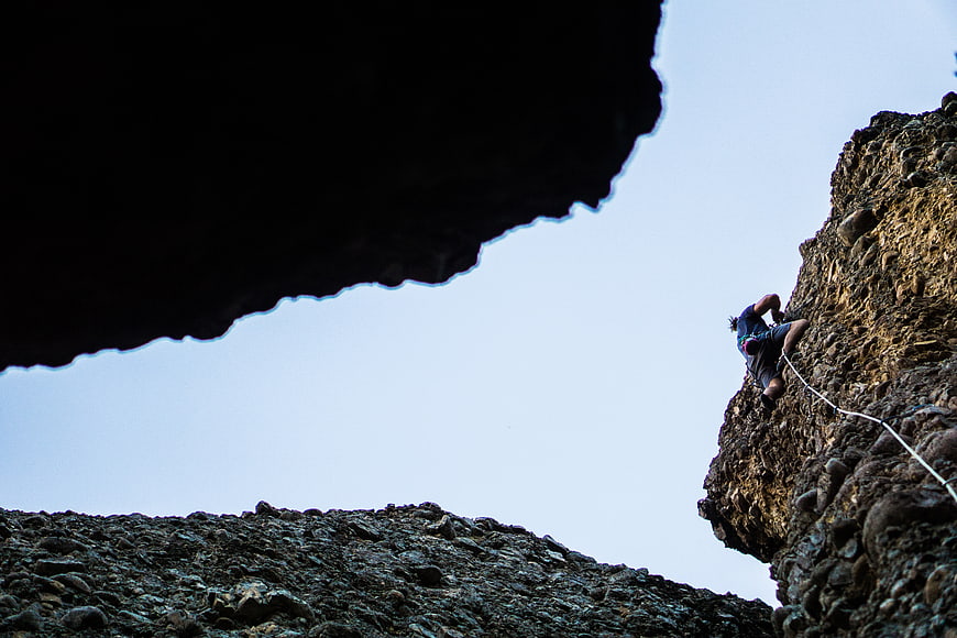 Rock Climber Scaling Cliff Face with Rope