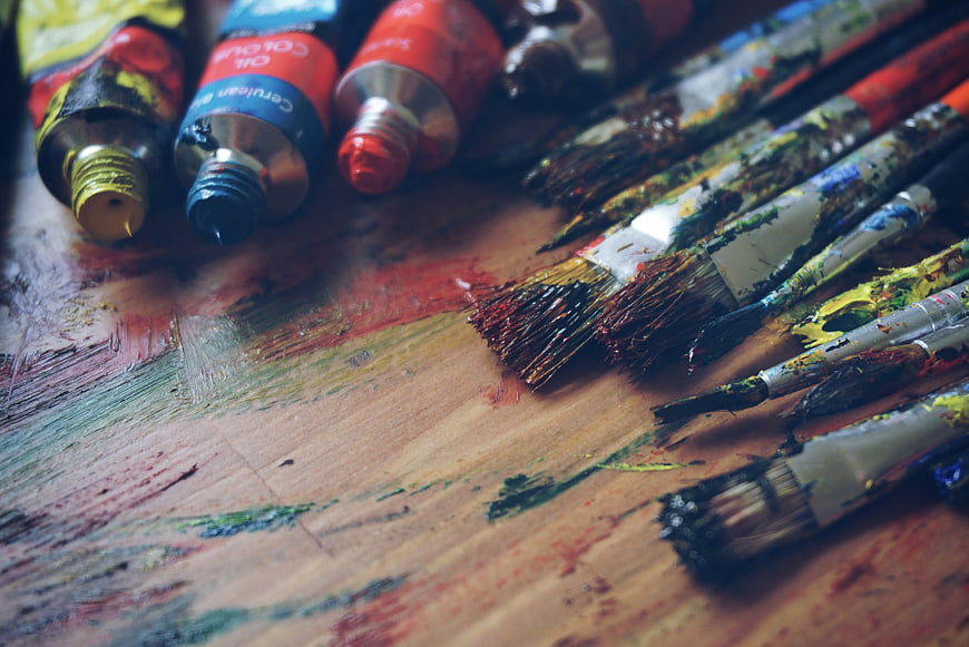 Used Oil Paint Brushes and Tubes on Wooden Palette
