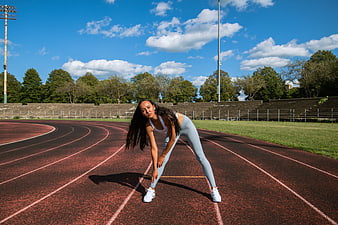 Female Athlete Stretching on Outdoor Running Track