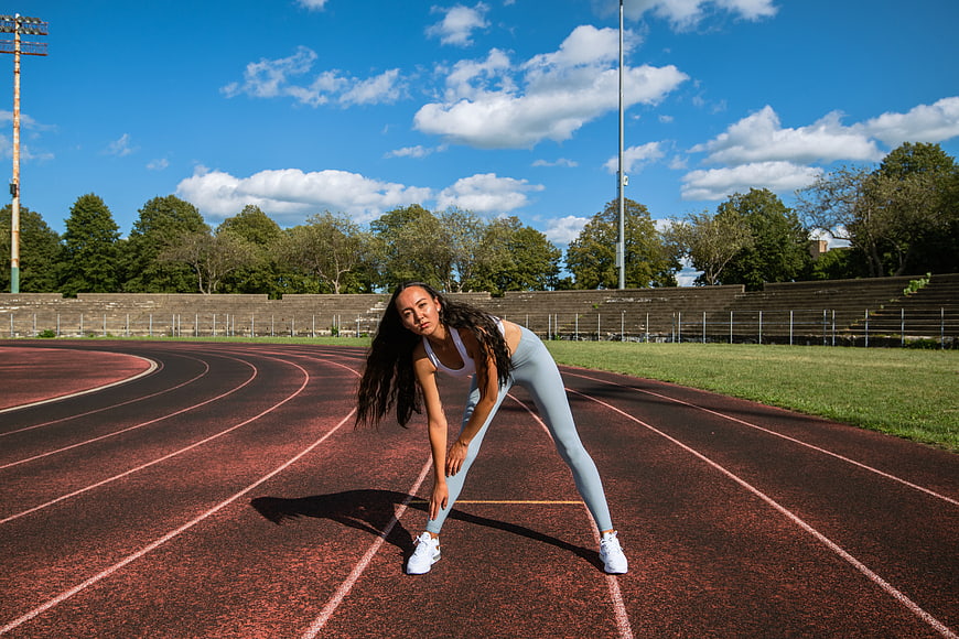 Female Athlete Stretching on Outdoor Running Track