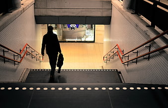 Silhouette of man walking down urban subway stairs