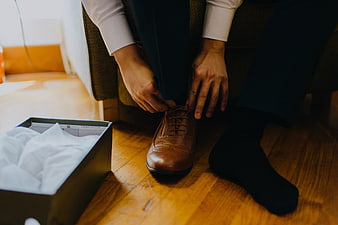 Man Tying Brown Leather Dress Shoes in Suit