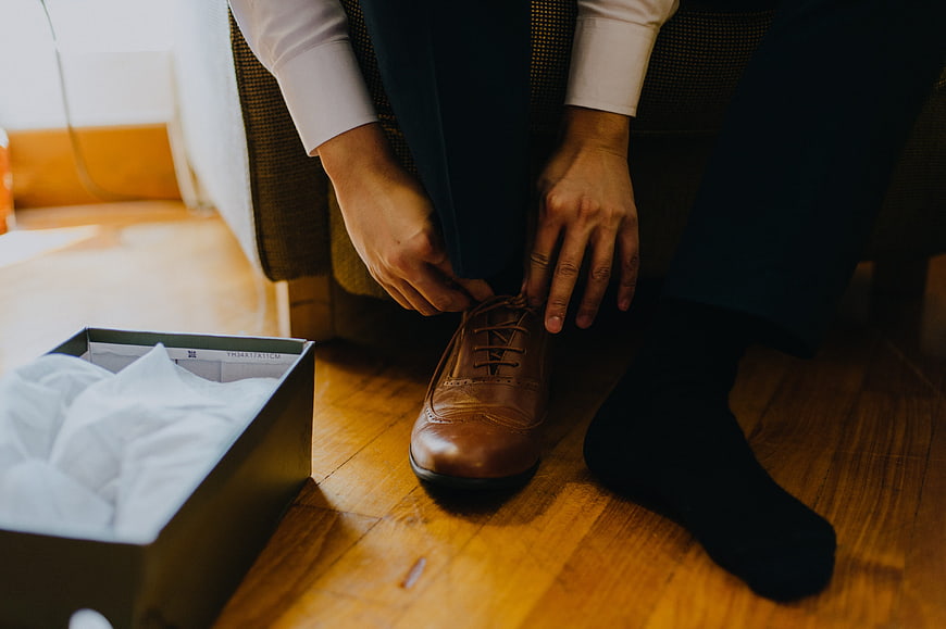 Man Tying Brown Leather Dress Shoes in Suit