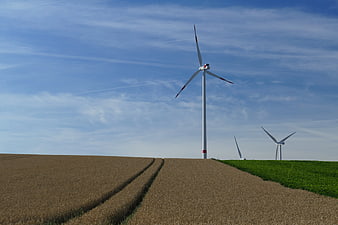 Wind turbines on rolling agricultural fields under blue sky