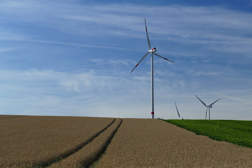 Wind turbines on rolling agricultural fields under blue sky