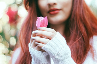 Woman with Red Hair Holding Pink Flower Petal