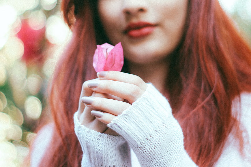 Woman with Red Hair Holding Pink Flower Petal
