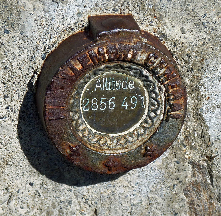 Rusted French Geodesic Altitude Marker on Concrete