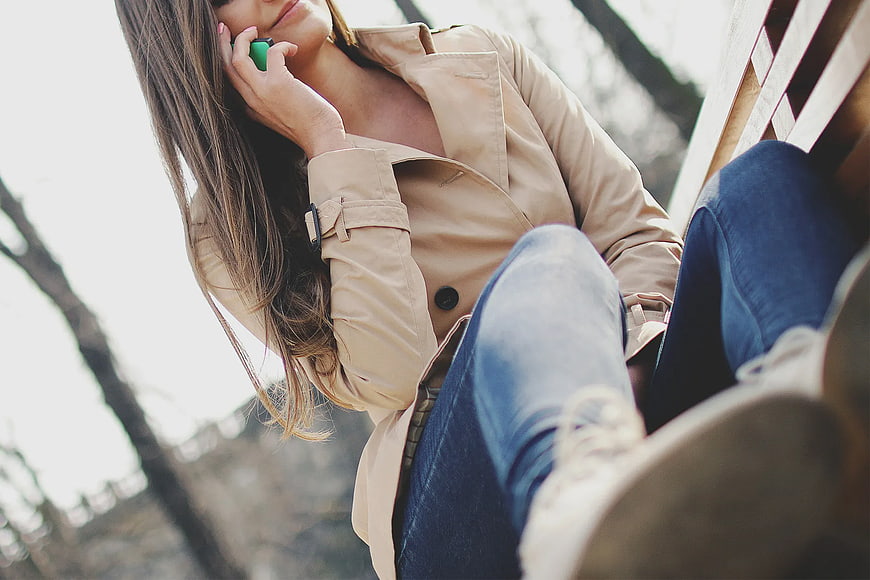 Woman in Trench Coat Talking on Smartphone Outdoors