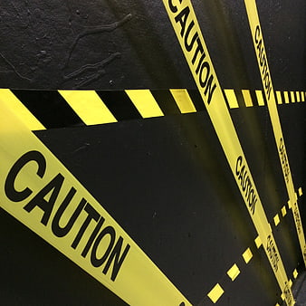 Yellow Caution Tape on Black Wall Background