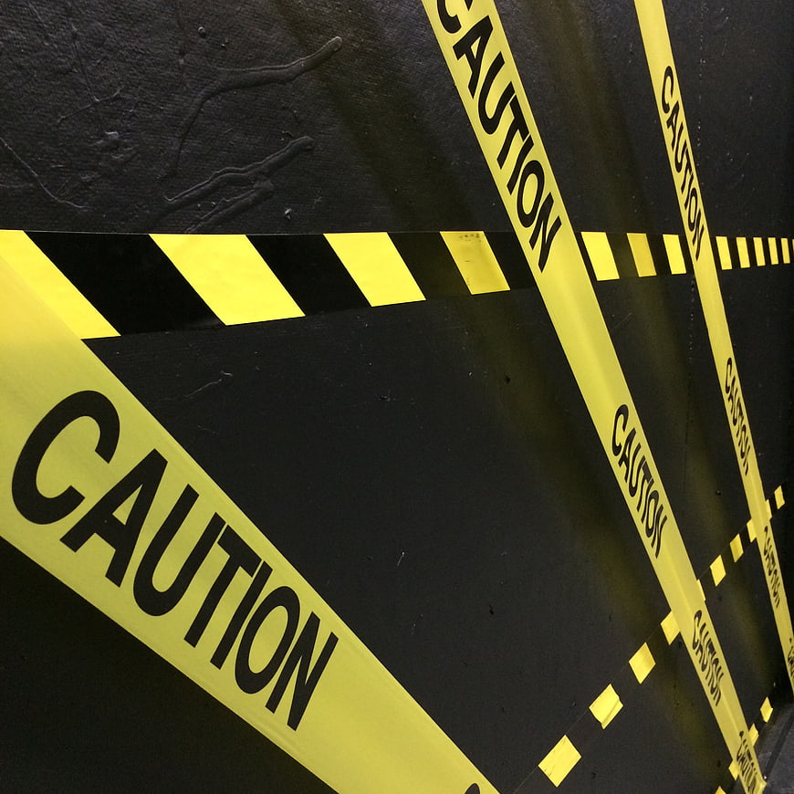 Yellow Caution Tape on Black Wall Background