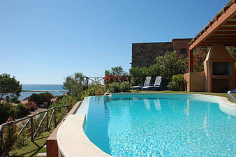 Luxury swimming pool with ocean view and lounge chairs
