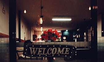 Vintage Welcome Sign with Red Roses in Coffee Shop Window
