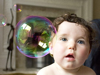 Curious Baby Watching Large Colorful Soap Bubble Indoors