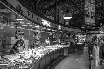 Black and white photo of a bustling indoor fish market
