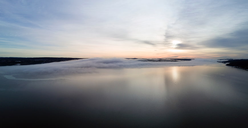 Aerial View of Misty Lake at Sunrise with Clouds