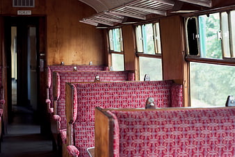 Vintage Train Interior with Red Patterned Seats and Wooden Walls