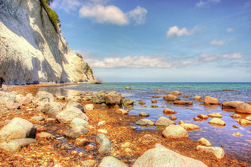 White chalk cliffs and rocky beach with seaweed