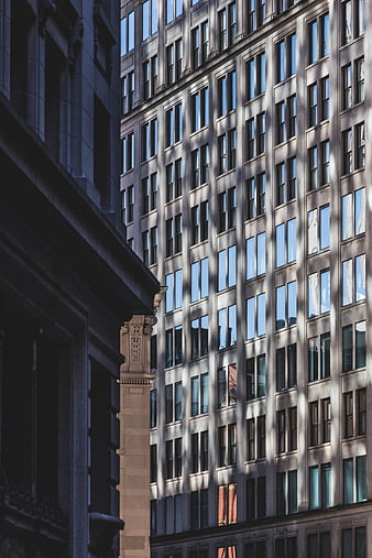 Modern skyscraper facade with geometric window patterns and shadows