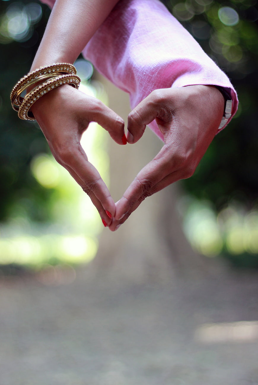 Woman's Hands Forming Heart Shape with Gold Bangle
