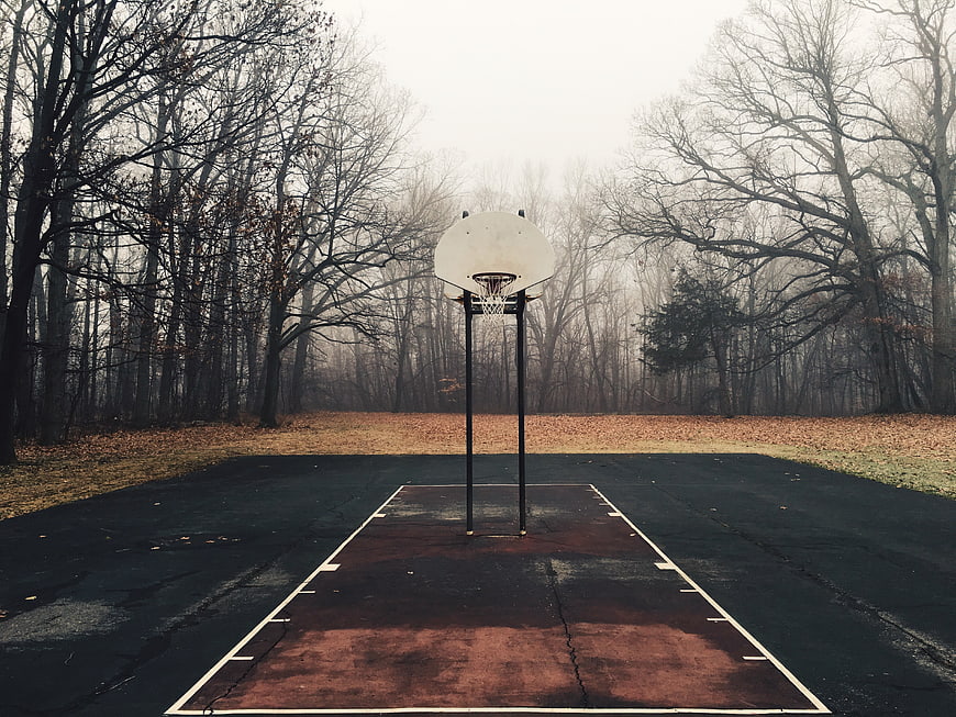 Empty outdoor basketball court in autumn forest