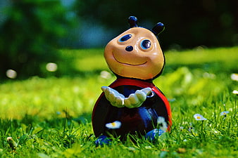 Cute Ladybug Garden Ornament Sitting In Green Grass