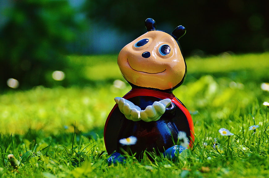 Cute Ladybug Garden Ornament Sitting In Green Grass